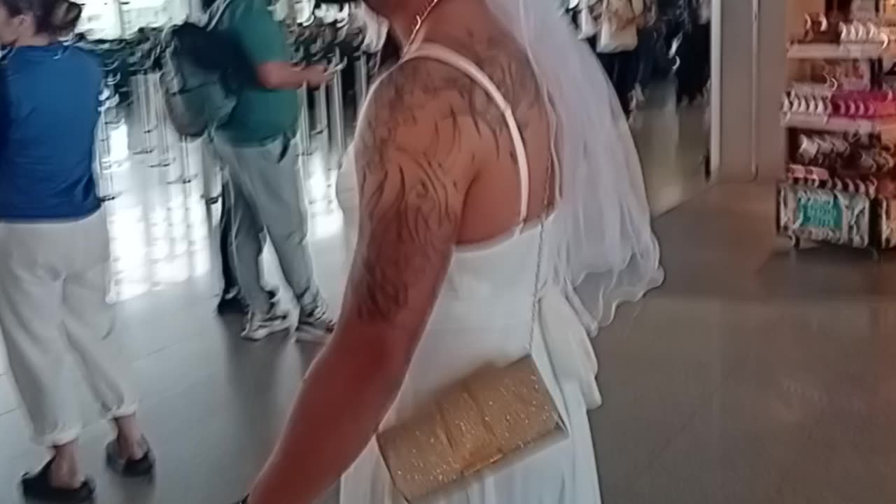 Man Walks Through Airport In Wedding Dress