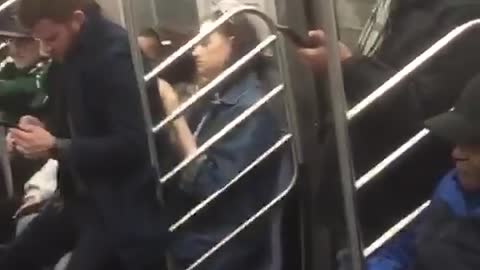 Man sits on girls lap on subway car