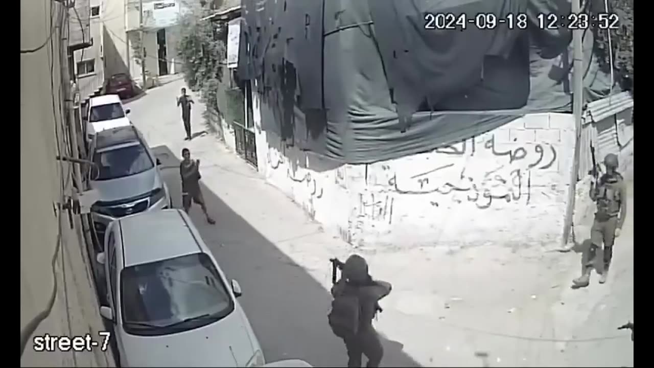 Israeli soldiers point weapons at children during a raid