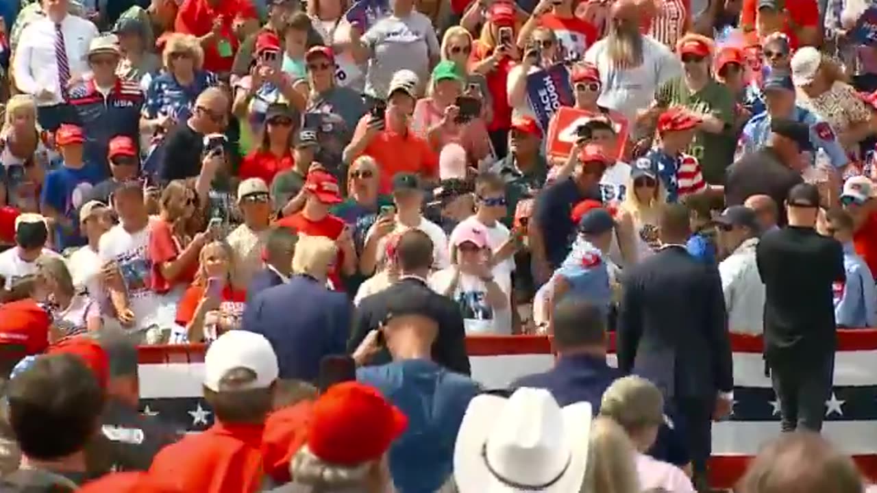 FEARLESS: Trump leaves bulletproof glass to check on a supporter who passed out.