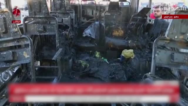 Charred smoking bus in Damascus bomb attack aftermath that killed 14