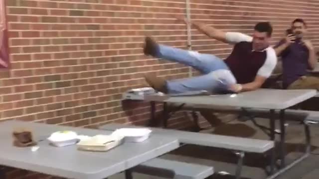 Michigan vs penn state guy tries to jump on table ripped jeans red shirt