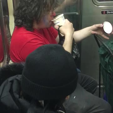 Long haired man licks pint of ice cream