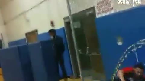 Senior year basketball court guy jumps into blue mat