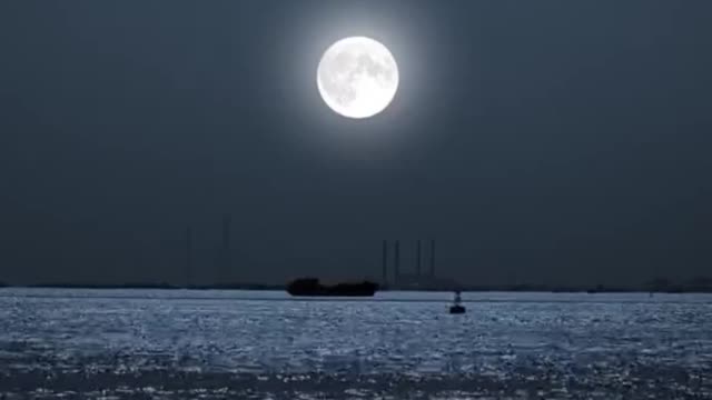 The moon is climbing up above the sea.