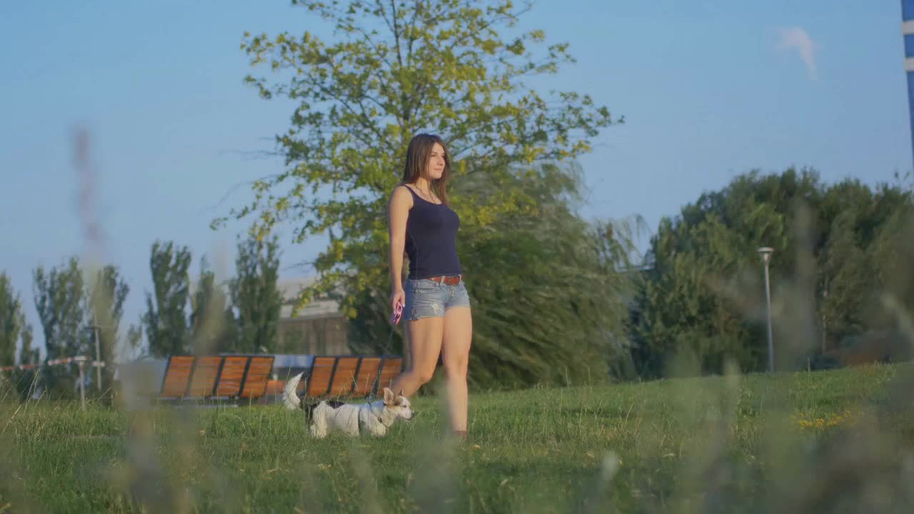 A woman is walking with a dog on a leash