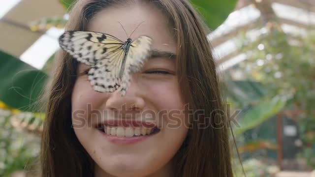 beautiful girl smiling with butterfly on face fluttering wings having fun