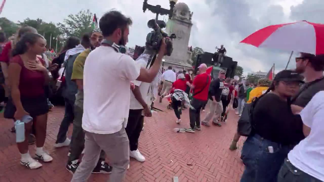 A man saves a smoldering American flag from the center of the protest and is