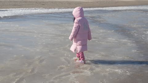 Cute girl is walking on the sea ice