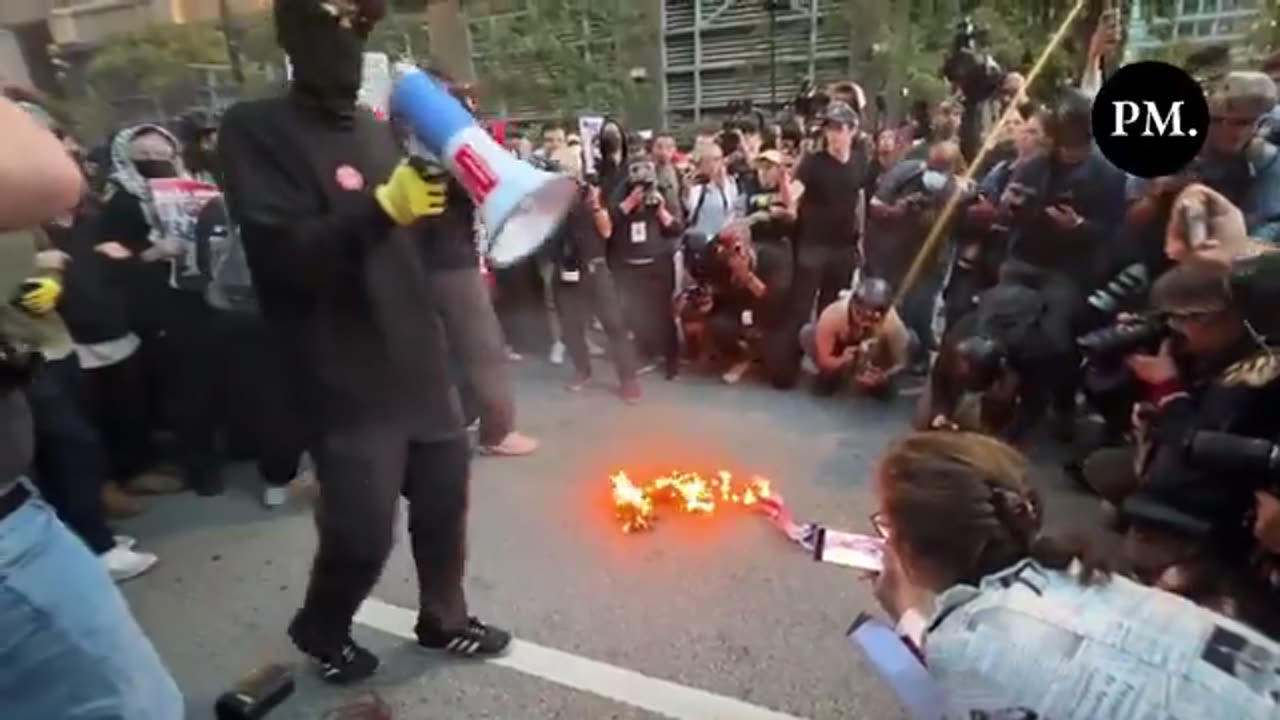 Real America's Voice's Ben Berquam tries to stop ANTIFA communist from setting U.S. flag on Fire