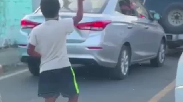 'Child plays with boy at traffic lights when stopping car' how beautiful this scene is