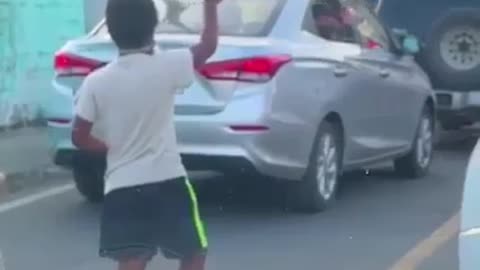 'Child plays with boy at traffic lights when stopping car' how beautiful this scene is