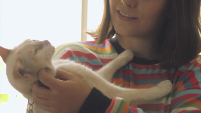 A woman petting and talking with her cat