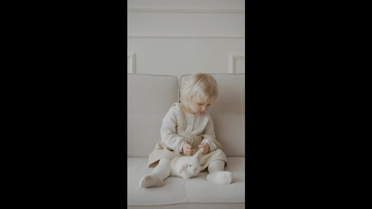 Baby Girl Plying with her Rabbit - Rabbit in her lap