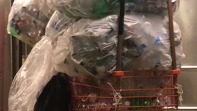 Orange shopping cart full of cans coming out of train