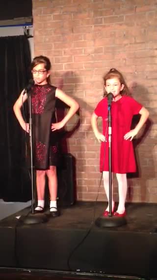 Little Girl Shoves Sister Off Stage While Performing Song About Sisters