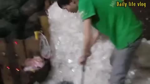 Workers are pushing used plastic bags down the heat machine