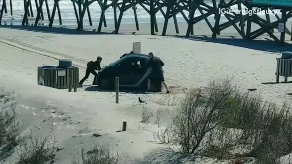 Guys get smart car stuck on beach near pier