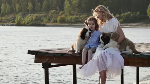 Little boy with mother near the sea playing with their dogs