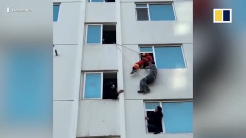 Chinese firefighter rescues elderly man hanging from fourth-floor window