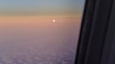 Moon below the horizon on one side of plane, sun on the other side