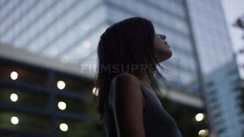 Woman looking up and admiring the tall buildings in a city