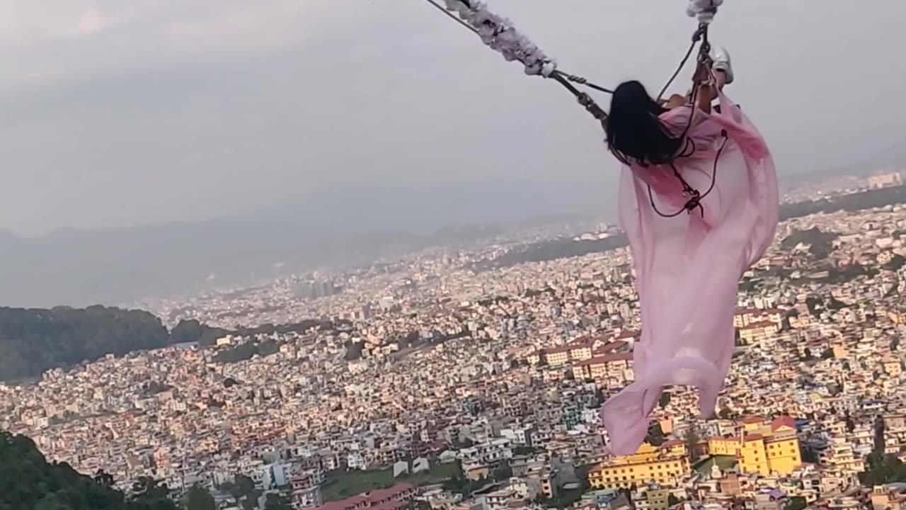 A beautiful Girl on Electric Swing on top of hill