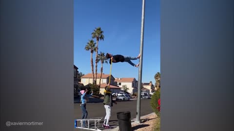 Man walking on street light poll