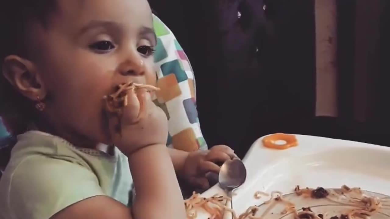 Funny baby eating spaghetti