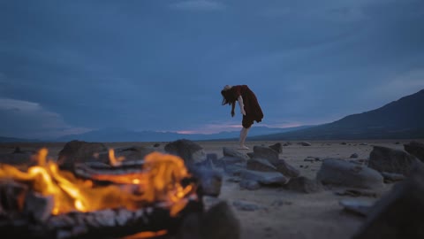 Abandoned plain with an open air fire and a lady rehearsing yoga