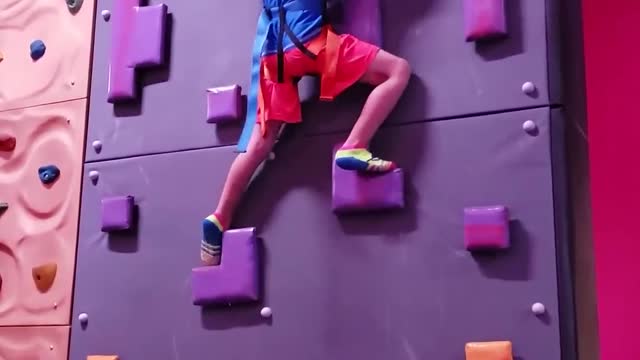 Little Boy Climbs On Rock Wall And Rings the Victory Bell