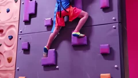 Little Boy Climbs On Rock Wall And Rings the Victory Bell