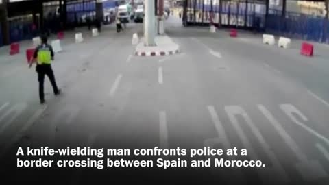 Spanish police throw traffic barrier at knife-wielding man
