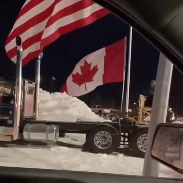 American & Canadian Truckers Fly Flags High & Proud Together in Protest