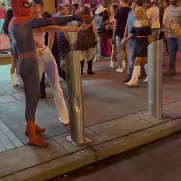 Person in Spider-Man costume partying on Lower Broadway