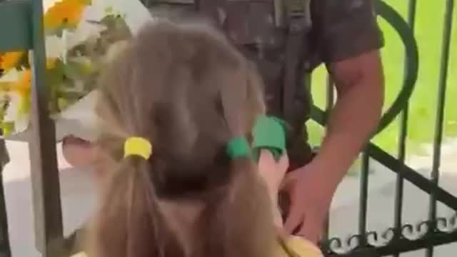 Young Brazilian girl hands flowers and flag to the military (Tears)