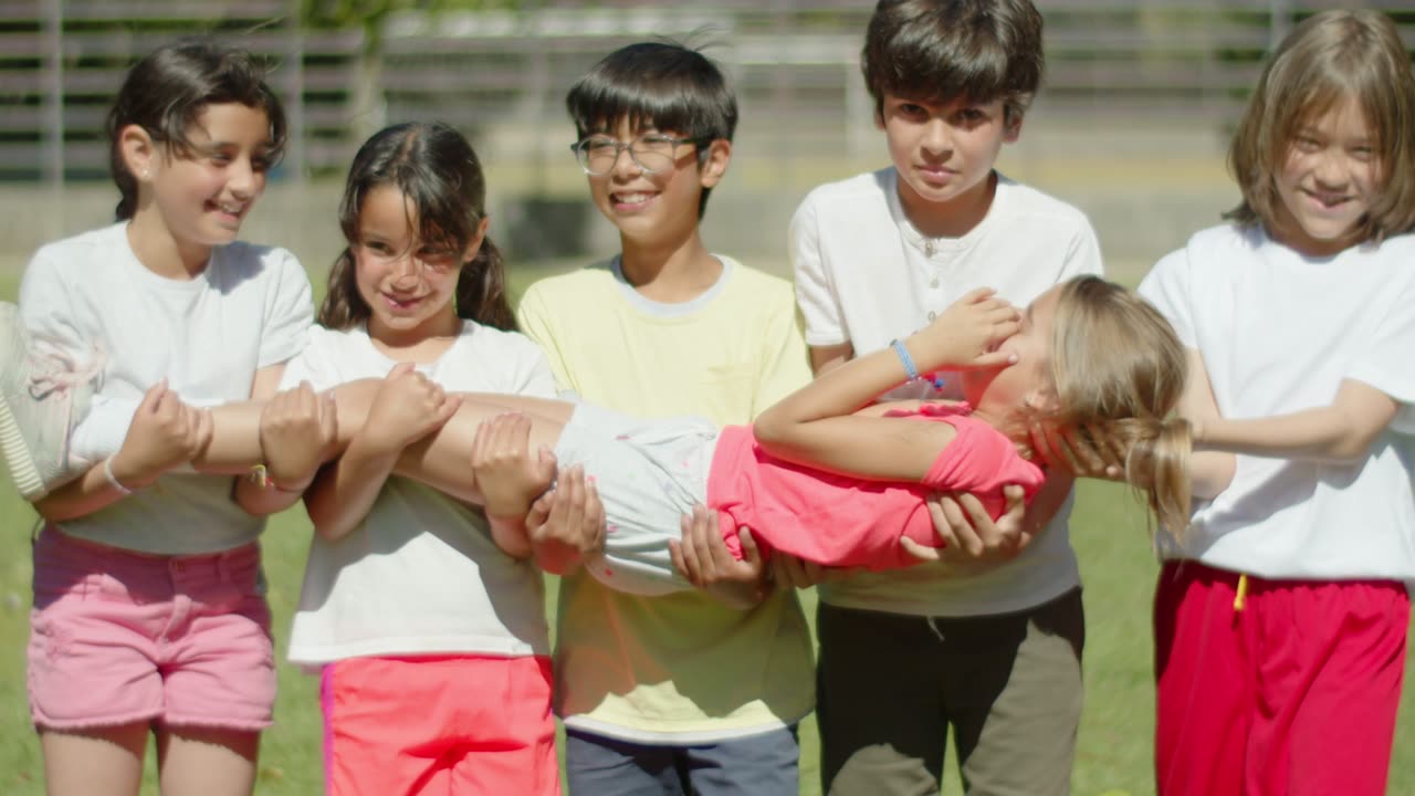 Children carrying a girl together