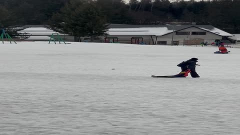 Mother Drags Sleepy Boy on Ski Slope