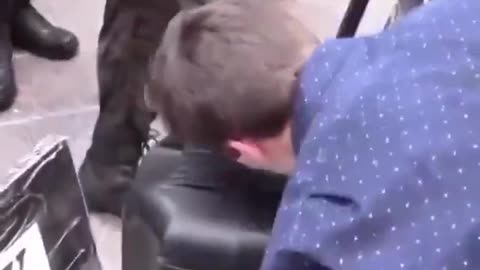 Two white people are seen kissing the boots of black men