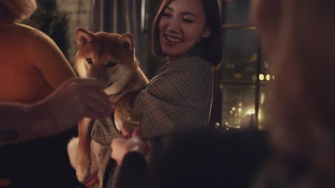 A Group Of People Teasing A Pet Dog With Bread For Food