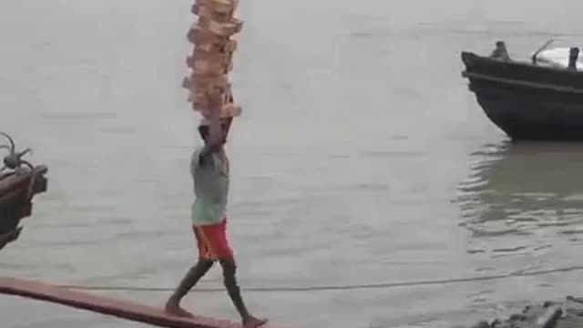 Boy balancing 22 bricks on his heads, without a single one dropping.