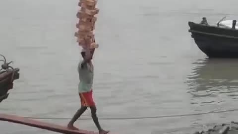 Boy balancing 22 bricks on his heads, without a single one dropping.