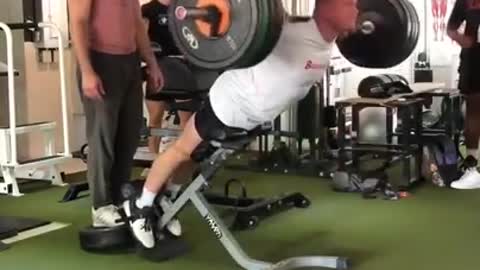 Man Performs Heavy Weight Back Extensions