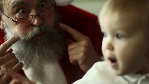 Santa Claus Making Faces With A Baby