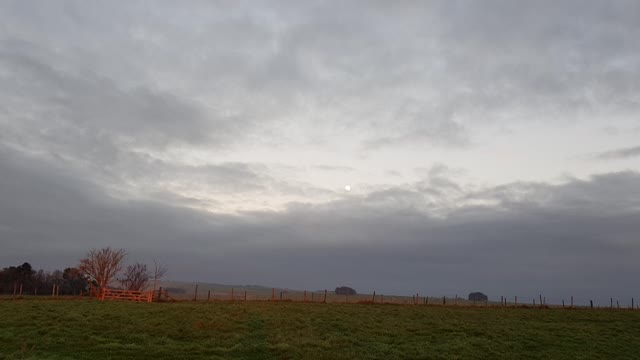 Sun is setting on a field in Avebury