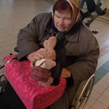 Hanna, her pigeon Serhii, and a toy rabbit at the railway station in Przemyśl, Poland