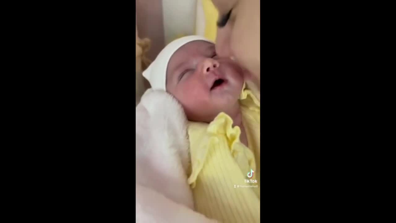 Newborn baby preciously smiles when kissed