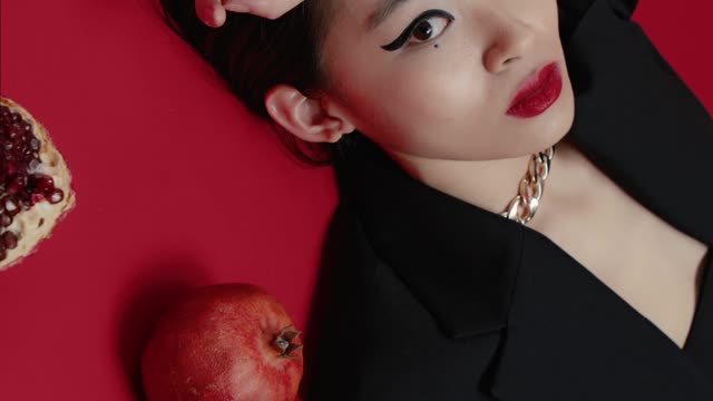 A Woman Lying on he Floor Surrounded by Pomegranate