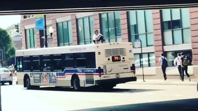 Guy Rides on Top of a Bus