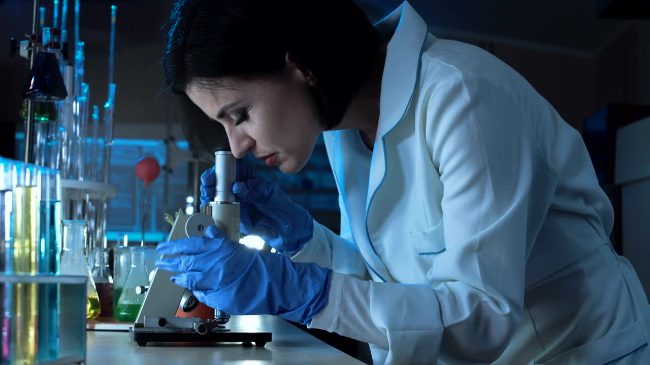 Woman working with microscope in the lab